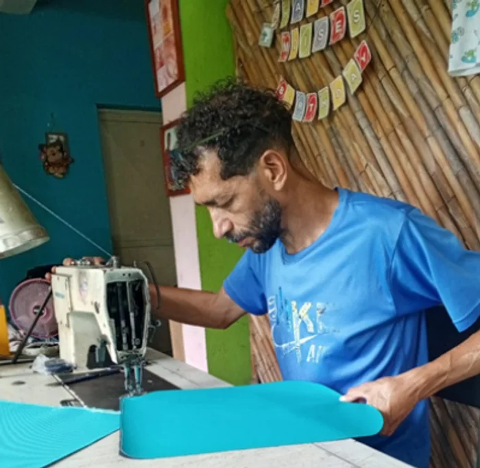 Moisés Guevara, artesano, cosiendo un morral en su taller de Caucagua